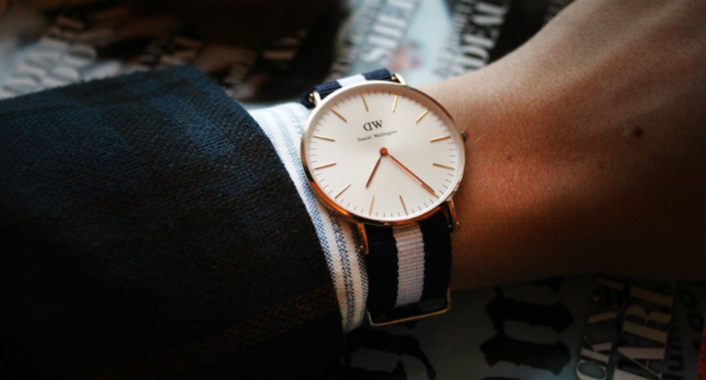 A clean cream watch with a blue and cream NATO strap